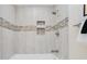 Well-maintained tub and shower combination with neutral tile and decorative niche at 4745 Dixie Dr, Ponce Inlet, FL 32127