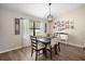 Dining area with wood floors, a modern chandelier, and custom decorative wall art at 4836 Ne 26Th Ter, Ocala, FL 34479