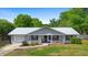Charming single-story home with a new silver metal roof, inviting front porch, manicured lawn and mature landscaping at 4836 Ne 26Th Ter, Ocala, FL 34479