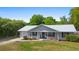 Charming single-story home with a new silver metal roof, inviting front porch, manicured lawn and mature landscaping at 4836 Ne 26Th Ter, Ocala, FL 34479