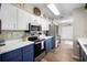 Bright kitchen featuring white countertops, stainless steel appliances, and blue bottom cabinets at 4836 Ne 26Th Ter, Ocala, FL 34479