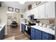 Bright kitchen with white cabinets, blue base cabinets, stainless appliances, modern fixtures, and wood grain floors at 4836 Ne 26Th Ter, Ocala, FL 34479