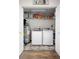 Organized laundry room with washer, dryer, water heater, and shelves for storage at 4836 Ne 26Th Ter, Ocala, FL 34479