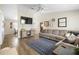 Comfortable living room featuring a large sectional, modern ceiling fan, and wood-look flooring at 4836 Ne 26Th Ter, Ocala, FL 34479