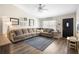 Comfortable living room with a large sectional, modern ceiling fan, and custom wall decor at 4836 Ne 26Th Ter, Ocala, FL 34479