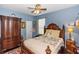 Cozy bedroom with blue walls, wooden furniture, and a ceiling fan for added comfort at 4901 Lake Milly Dr, Orlando, FL 32839