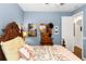 Bedroom featuring floral bedding, light blue walls, and a unique hat stand with a mirror at 4901 Lake Milly Dr, Orlando, FL 32839