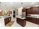 Well-appointed kitchen with dark wood cabinets, stainless steel appliances, and a marble-topped island at 4901 Lake Milly Dr, Orlando, FL 32839