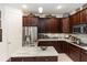 Gourmet kitchen featuring a stainless steel refrigerator, granite countertops, and custom cabinetry at 4901 Lake Milly Dr, Orlando, FL 32839