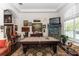 Spacious living room with a pool table, dark wood floors, and bright natural light at 4901 Lake Milly Dr, Orlando, FL 32839