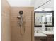 Detailed view of tiled shower with showerhead and built-in shelving in a luxurious bathroom at 4901 Lake Milly Dr, Orlando, FL 32839