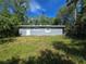 A one-story home with a gray exterior, surrounded by lush greenery and a grassy yard at 508 N Keech St, Daytona Beach, FL 32114