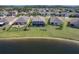 Aerial view of lakeside homes featuring screened patios, manicured lawns, and neighborhood tranquility at 5298 Bear Corn Run, Port Orange, FL 32128