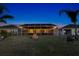 A cozy backyard featuring a screened-in patio with outdoor lighting and a stone fire pit at 5298 Bear Corn Run, Port Orange, FL 32128