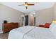 Bright bedroom with wood floors, a ceiling fan, and access to the bathroom at 5298 Bear Corn Run, Port Orange, FL 32128