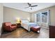 Well-lit bedroom with a ceiling fan, wood floors, and an accent chair at 5298 Bear Corn Run, Port Orange, FL 32128