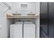Laundry room with washer, dryer, cabinets, and black door at 5298 Bear Corn Run, Port Orange, FL 32128