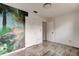 An empty bedroom with tile floors, a mural, and natural light from a large window at 600 Holmes Ave, Daytona Beach, FL 32114