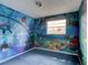 Spacious bedroom with unique ocean themed wallpaper and plush blue carpeting at 600 Holmes Ave, Daytona Beach, FL 32114