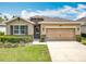 Charming single Gathering home showcasing a well manicured lawn, stylish stone accents, and a convenient two-car garage at 669 E Victoria Trails Blvd, Deland, FL 32724