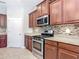 Well-equipped kitchen featuring granite countertops, stainless steel appliances, tile backsplash, and dark wood cabinetry at 669 E Victoria Trails Blvd, Deland, FL 32724