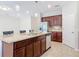 Modern kitchen with stainless steel appliances, dark wood cabinets, granite countertops, and a large island for cooking at 669 E Victoria Trails Blvd, Deland, FL 32724