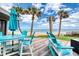 Relaxing back deck with beautiful ocean view and Adirondack chairs arranged around a patio table and umbrella at 787 Ocean Shore Blvd, Ormond Beach, FL 32176