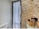 Unique bathroom featuring a wooden sink, stone accent wall, and sheer curtain to outside at 787 Ocean Shore Blvd, Ormond Beach, FL 32176