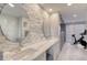 Modern bathroom featuring double sinks, stone accent wall, and exercise bike at 787 Ocean Shore Blvd, Ormond Beach, FL 32176
