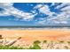 Expansive beach view showcasing beautiful blue skies and ocean waves along sandy shore at 787 Ocean Shore Blvd, Ormond Beach, FL 32176