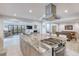 Open kitchen featuring a large island with cooktop, counter seating, and a view of the cozy living area at 787 Ocean Shore Blvd, Ormond Beach, FL 32176