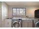Bright laundry room with a modern washer and dryer, complemented by a stainless steel sink and countertop space at 787 Ocean Shore Blvd, Ormond Beach, FL 32176