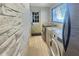 Laundry room boasts modern appliances, a window, and stylish tiled flooring at 787 Ocean Shore Blvd, Ormond Beach, FL 32176