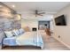 Open bedroom with hardwood floors, a fireplace, a mounted tv, and a ceiling fan at 787 Ocean Shore Blvd, Ormond Beach, FL 32176
