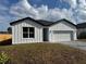 Charming single-story home with a white exterior, dark roof, two-car garage, and well-manicured lawn at 810 W 24Th St, Sanford, FL 32771
