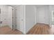 Bright hallway featuring wood-look flooring, white trim, and multiple access doors at 810 W 24Th St, Sanford, FL 32771