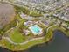 Aerial view of a neighborhood pool and clubhouse surrounded by a lake and lush landscaping at 8561 Randal Park Blvd, Orlando, FL 32832