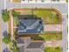 Aerial view of a corner-lot home featuring solar panels, a fenced yard, and brick driveway at 8561 Randal Park Blvd, Orlando, FL 32832