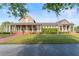 A well-manicured lawn leads to the stone and siding clubhouse, framed by mature trees and a clear blue sky at 8561 Randal Park Blvd, Orlando, FL 32832