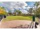 Brick patio at dog park offering green space, waste disposal, and seating next to an iron fence at 8561 Randal Park Blvd, Orlando, FL 32832