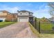 Two-story home features a front yard, brick driveway, a garage, and a black metal fence at 8561 Randal Park Blvd, Orlando, FL 32832