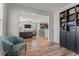 Open-concept living area with hardwood floors, view to the kitchen, built-in bookcases, and modern furnishings at 8561 Randal Park Blvd, Orlando, FL 32832