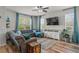 Comfortable living room with plush seating, a ceiling fan, hardwood floors, and a large TV for entertainment at 8561 Randal Park Blvd, Orlando, FL 32832