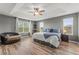 Spacious main bedroom featuring tray ceilings, ceiling fan, and wood floors at 8561 Randal Park Blvd, Orlando, FL 32832