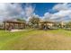 A playground with a covered play structure and shaded benches sits on a large grassy lawn at 8561 Randal Park Blvd, Orlando, FL 32832