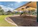 A covered playground structure featuring two slides is set on mulch and surrounded by a brick border at 8561 Randal Park Blvd, Orlando, FL 32832