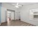 Bright bedroom featuring wood floors, a ceiling fan, neutral walls, and natural light from the large window at 914 Smokerise Blvd, Port Orange, FL 32127