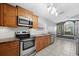 Well-equipped kitchen with stainless steel appliances, wood cabinets, and a tiled floor at 914 Smokerise Blvd, Port Orange, FL 32127
