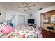Bright bedroom with a floral-patterned bedspread, a ceiling fan, and an attached bathroom vanity at 950 Windway Cir, Kissimmee, FL 34744
