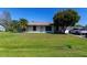 Charming single-story home with a well-maintained lawn, mature trees, and a paved driveway at 950 Windway Cir, Kissimmee, FL 34744